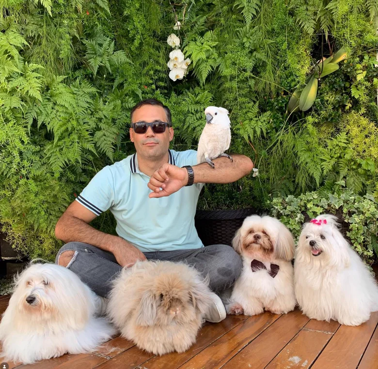 Kleber Vasconcelos em harmonia com seus cães, cacatua e coelho, num jardim vertical